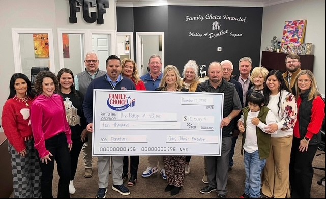 Group of people presenting an oversized check to the Refuge of MS Downs Syndrome Daycare