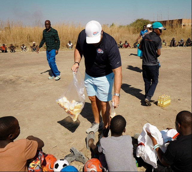 Handing out snacks to children after playing soccer